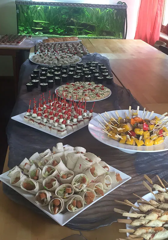Reichhaltiges Fingerfood-Buffet mit Wraps, Caprese-Spießen und Gemüse-Spießen für eine Feier.