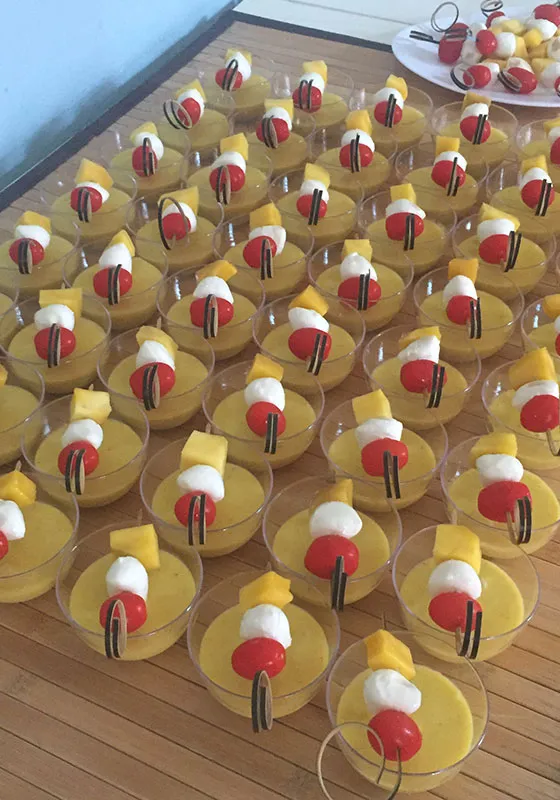 Fingerfood-Variation: Mango-Mousse im Glas mit Mozzarella-Tomaten-Spießchen.